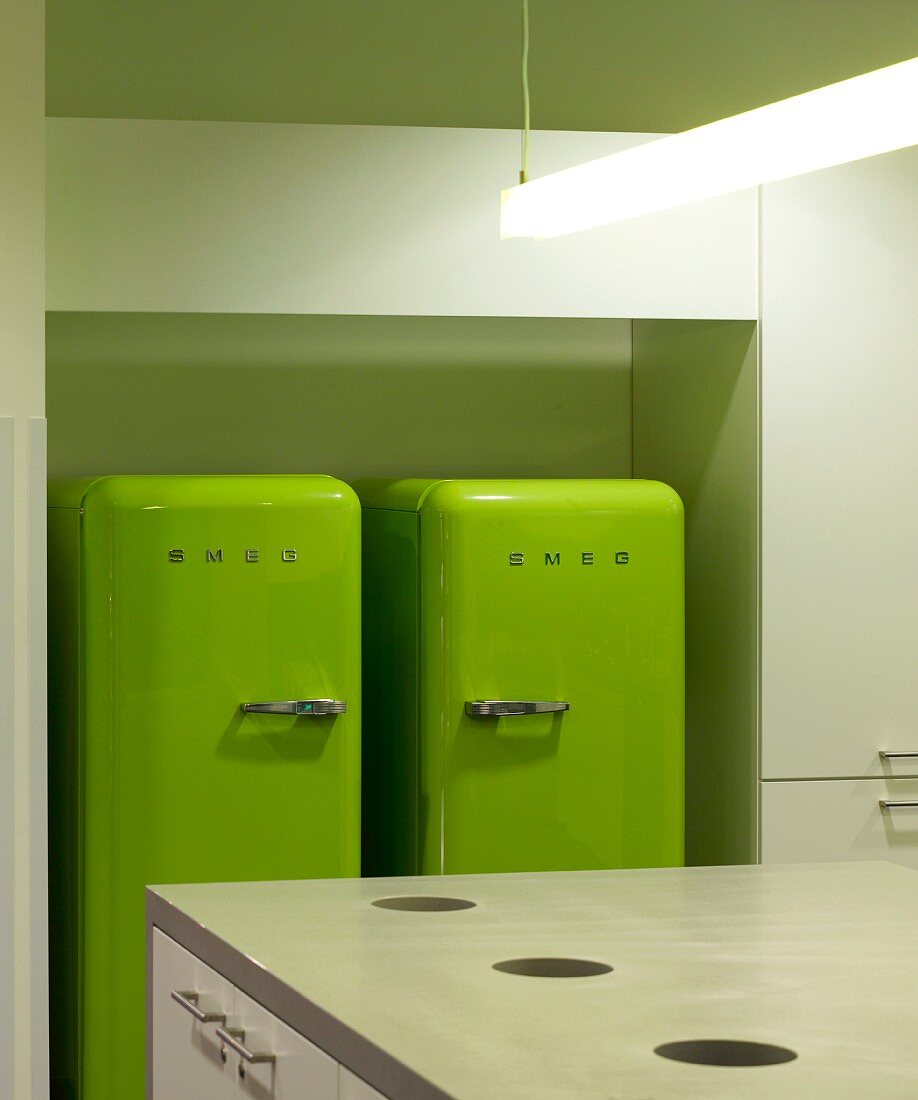 Two green refrigerators in an office kitchen