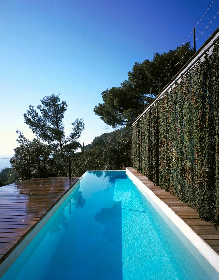Terrasse mit Pool, auf der einen Seite mit geschlossenen Vorhängen, auf der andern mit Blick zum Meer