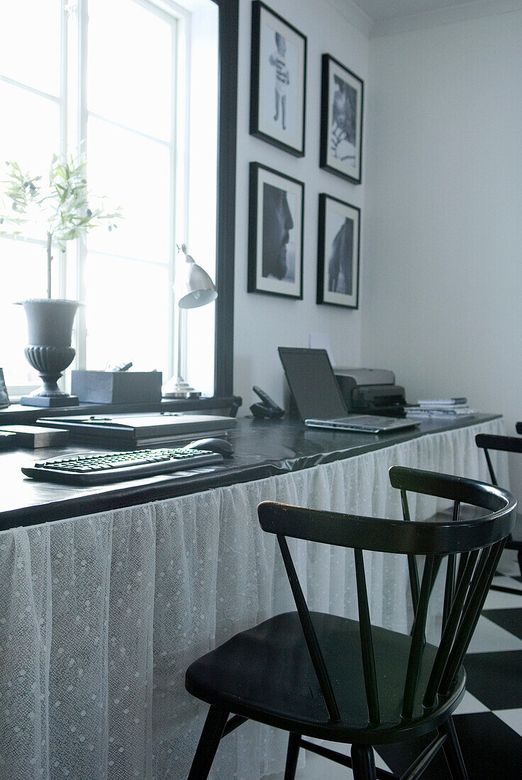 Home office with black picture frames and black wooden chairs