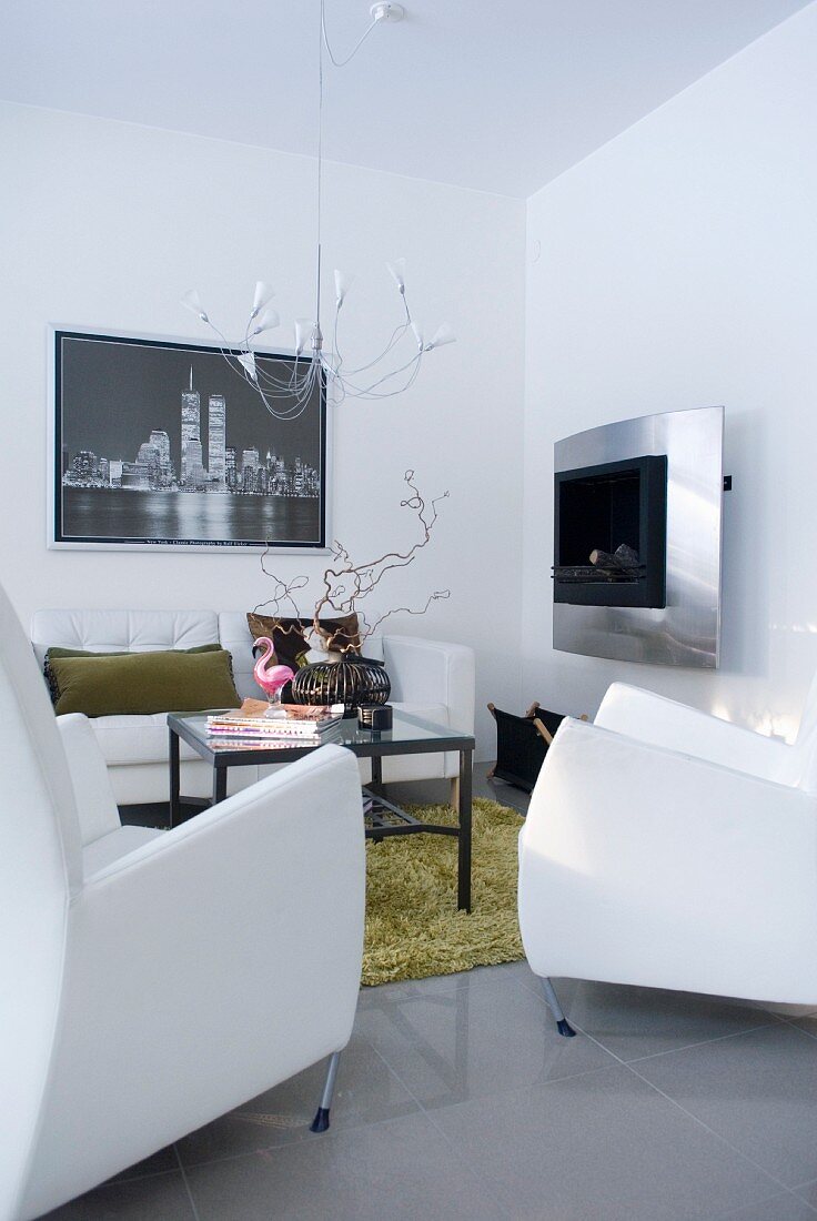 A modern seating area with white designer furniture and a stainless steel fireplace
