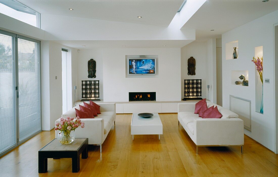 Elegant living room with white sofas on wooden floorboards