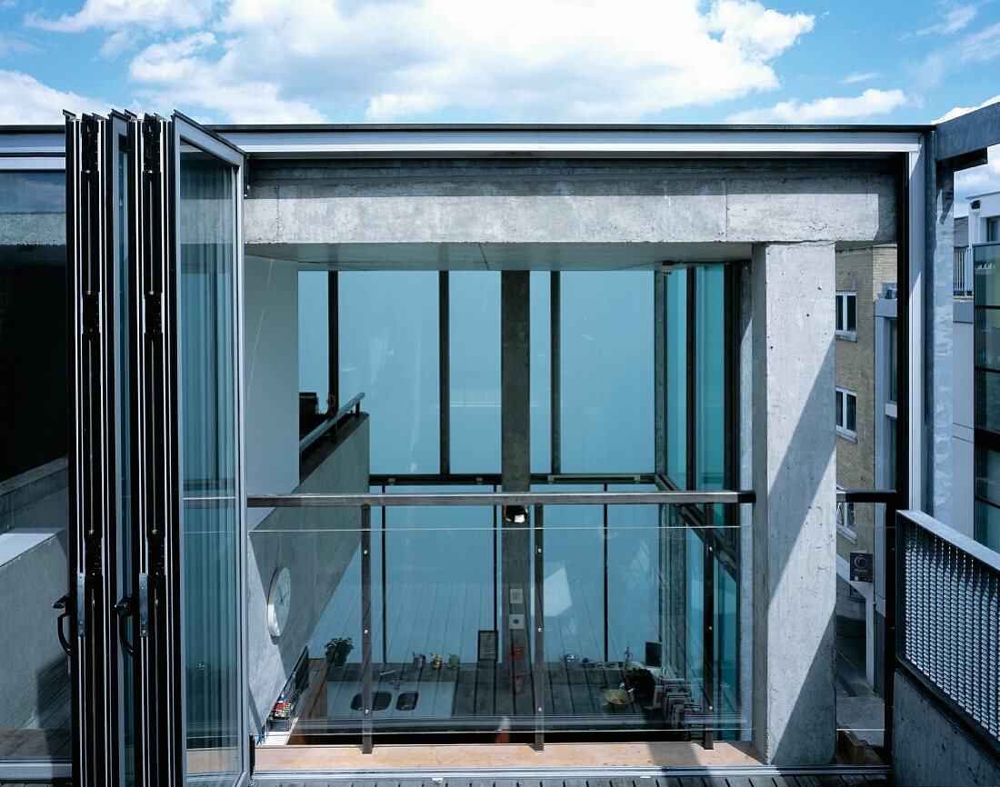 Dachterrasse mit offener Glasfalttür und Blick auf Galerie und in Innenraum