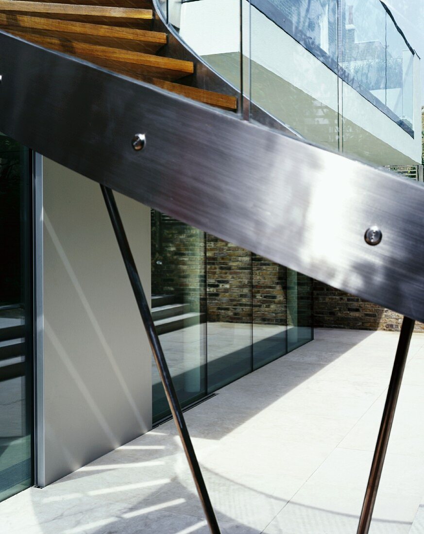 Stainless steel stringer on curved staircase in courtyard of contemporary house