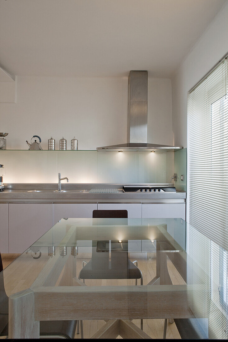 Kitchen with glass dining table and extractor hood