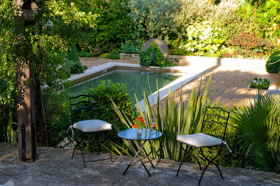 Sitzplatz mit Blick auf Schwimmteich und Gartenbepflanzung