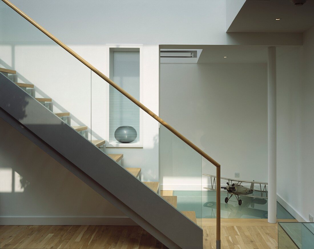 Contemporary staircase in bright stairwell and ceiling-height doorway to hall