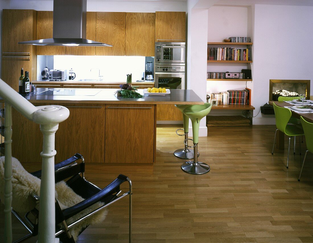 Offene Küche mit Küchenblock und Designer Barhockern mit grünen Sitzschalen