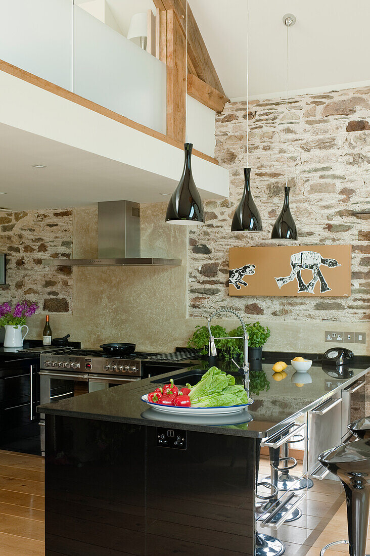 Küche mit Kochinsel und freiliegendem Mauerwerk