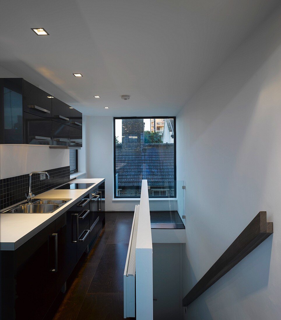 Moderne Küche mit Fenster zum Nachbardach und Treppe