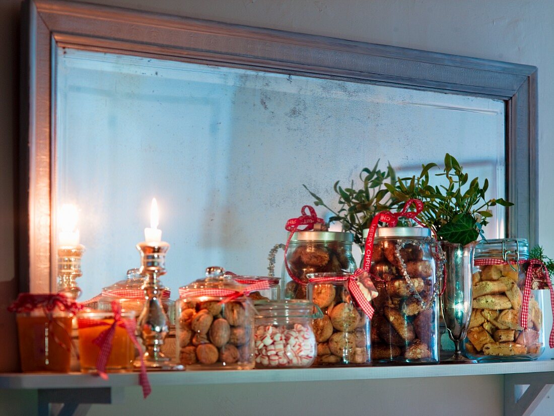 Verschiedene Weihnachtsplätzchen, Marmelade, Nüsse und Bonbons am Wandboard