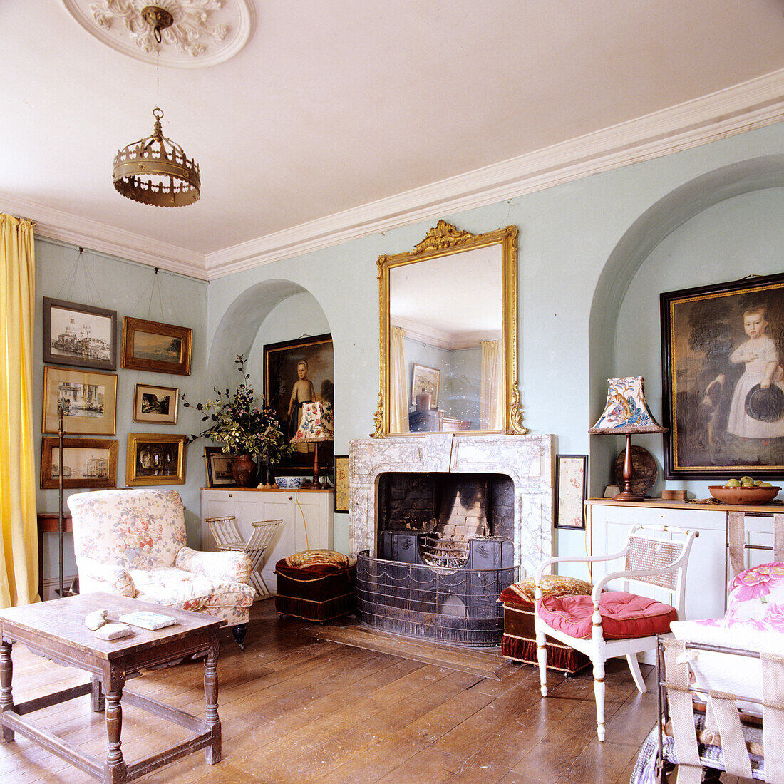 Historic living room with fireplace, gold-framed mirror and picture gallery