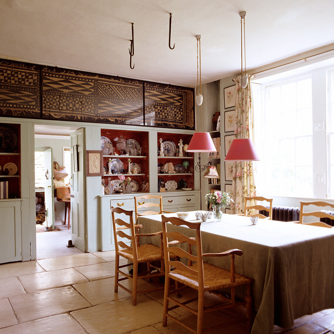 Wooden table and chairs in kitchen with traditional furnishings and shelves