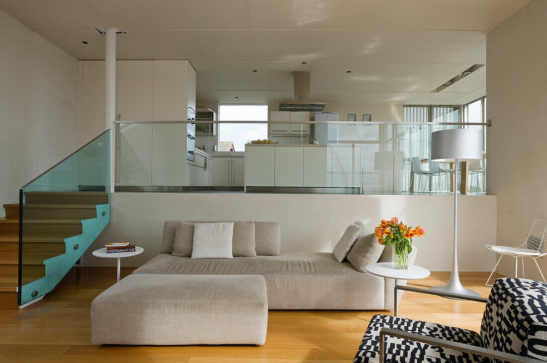 Wooden staircase with glass wall and sofa in beige