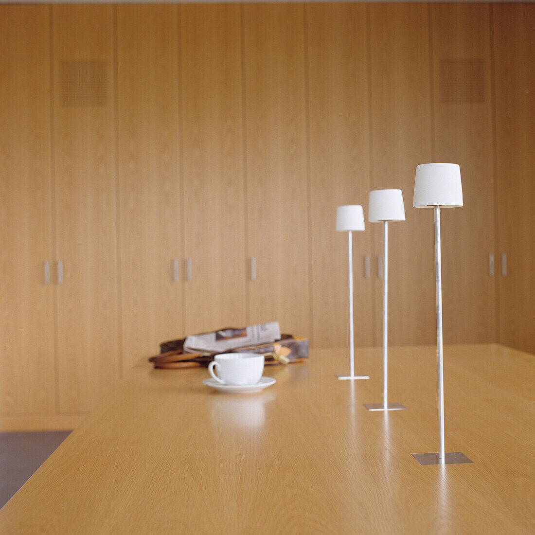 Minimalist dining area with white table lamps and wooden furniture