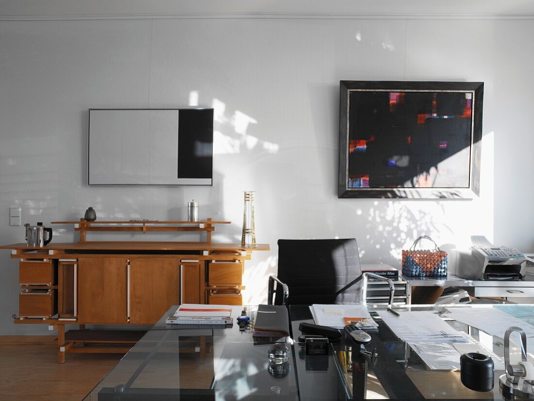 Stilmix in Arbeitszimmer mit modernen Stahl/Glas-Möbeln und Sideboard aus Buche im Retrostil