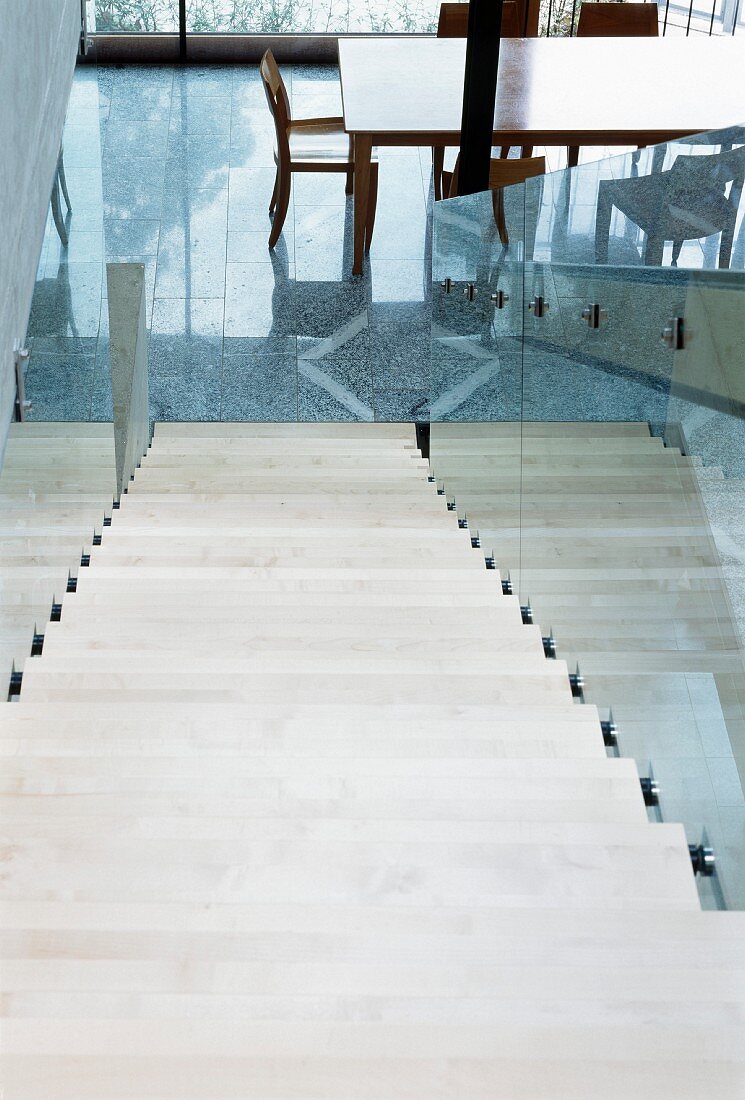 Treppenabgang mit Geländer aus Glas an abgehängtem Stahlträger und Blick auf Essplatz