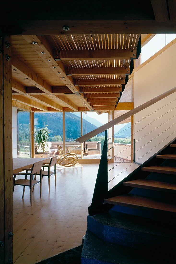 Zeitgenössisches Holzhaus - Treppe zu Galerie im offenen, hellen Wohnraum mit Blick in Berglandschaft