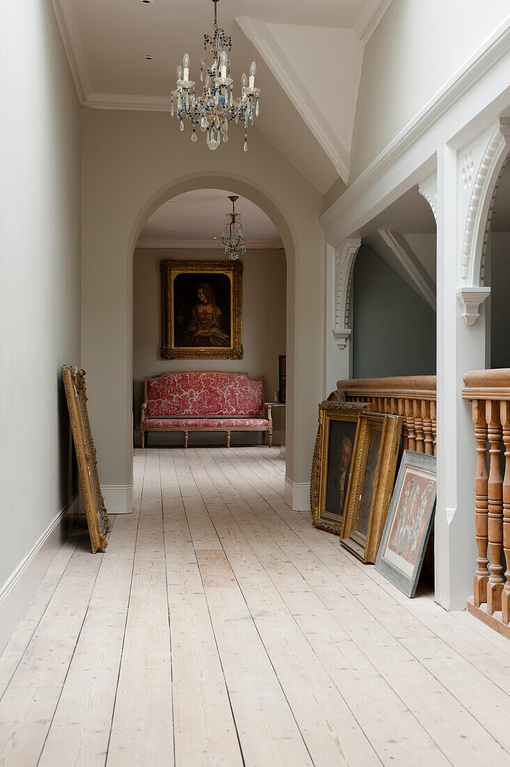 Flur mit Kronleuchtern, Gemälden und Dielenboden in einem historischen Haus