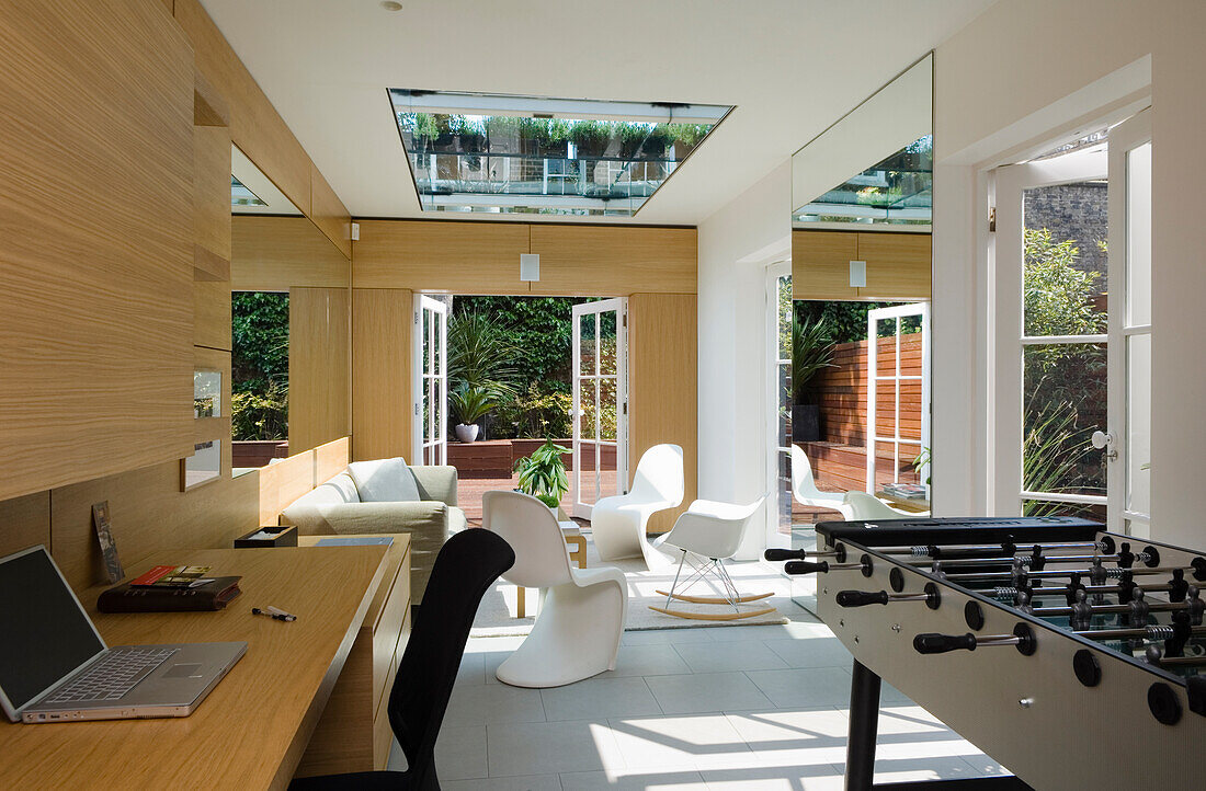 Living room with skylight, white furnishings and foosball table