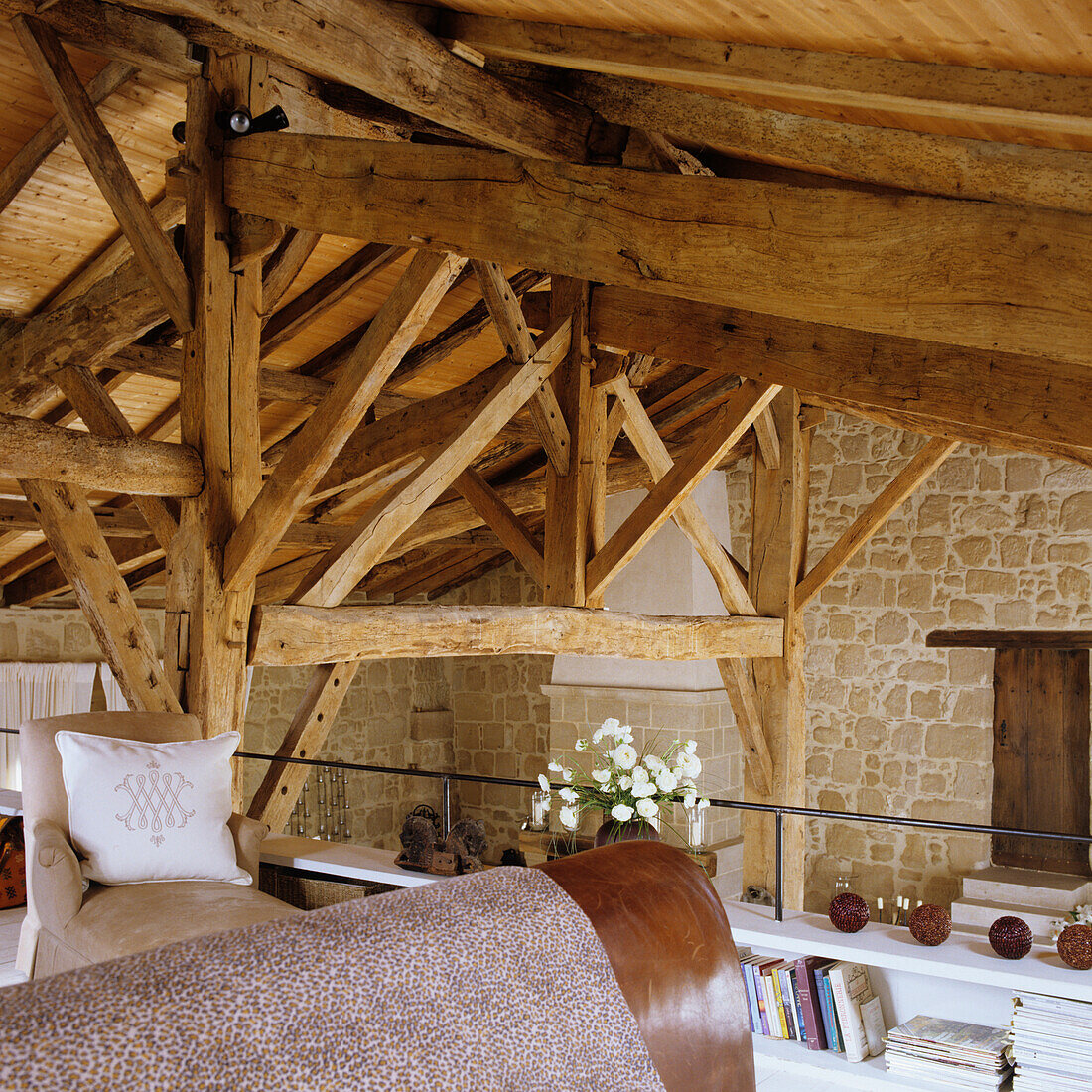 Holzbalken im Dachgeschoss, Steinwand und Sitzgelegenheiten