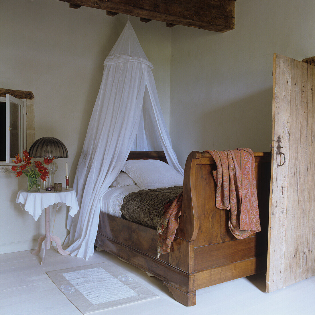 Rustic bedroom with antique wooden bed and bed canopy