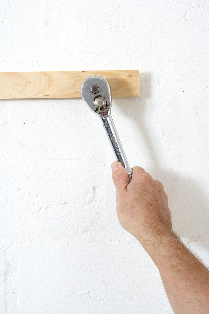 Screwing screws into wall