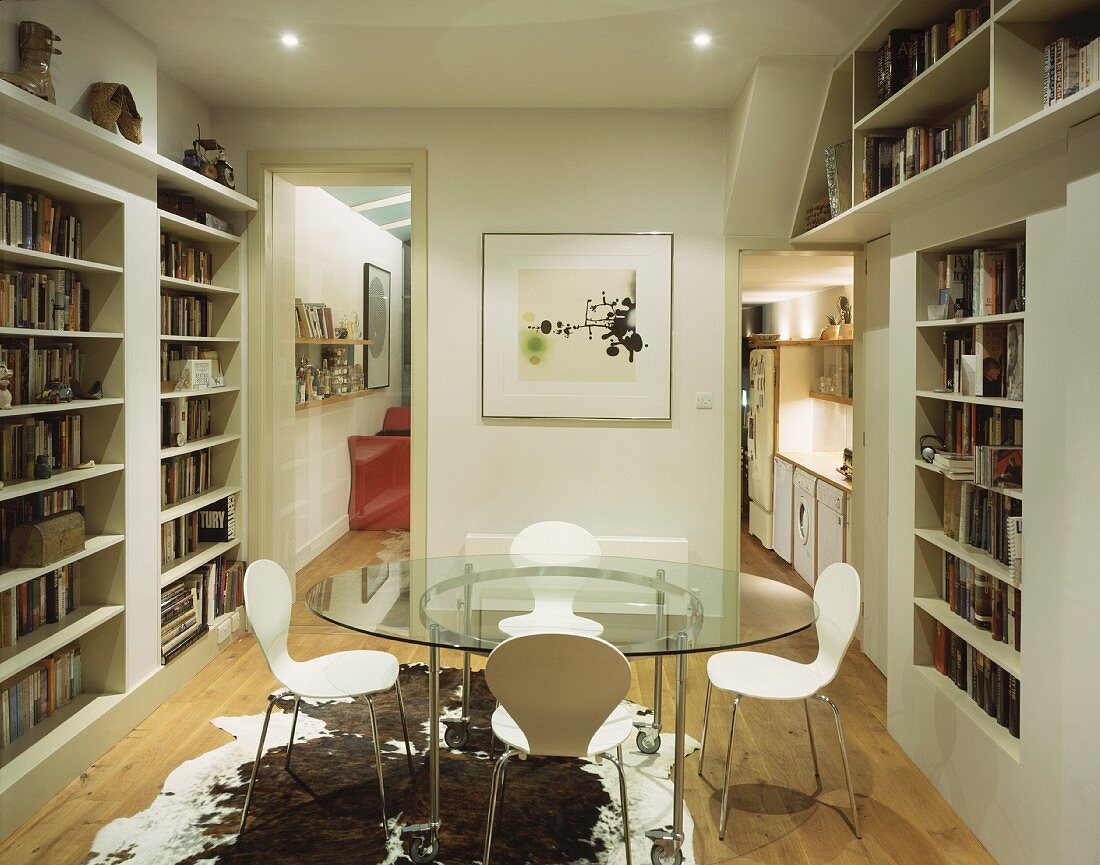 Room with round glass table and built-in bookcases