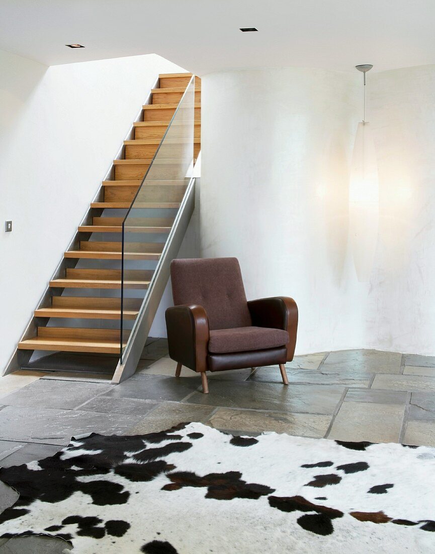 Contemporary staircase in purist living space with cow skin rug on stone floor