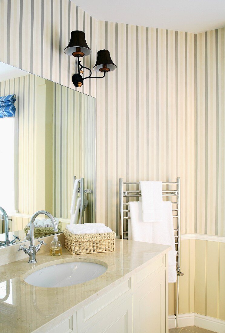 Cream, traditional-style bathroom with striped wallpaper, lamps with lampshades and marble washstand