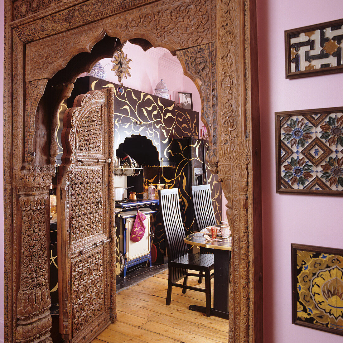 Kitchen with ornately carved wooden doorway and oriental motifs