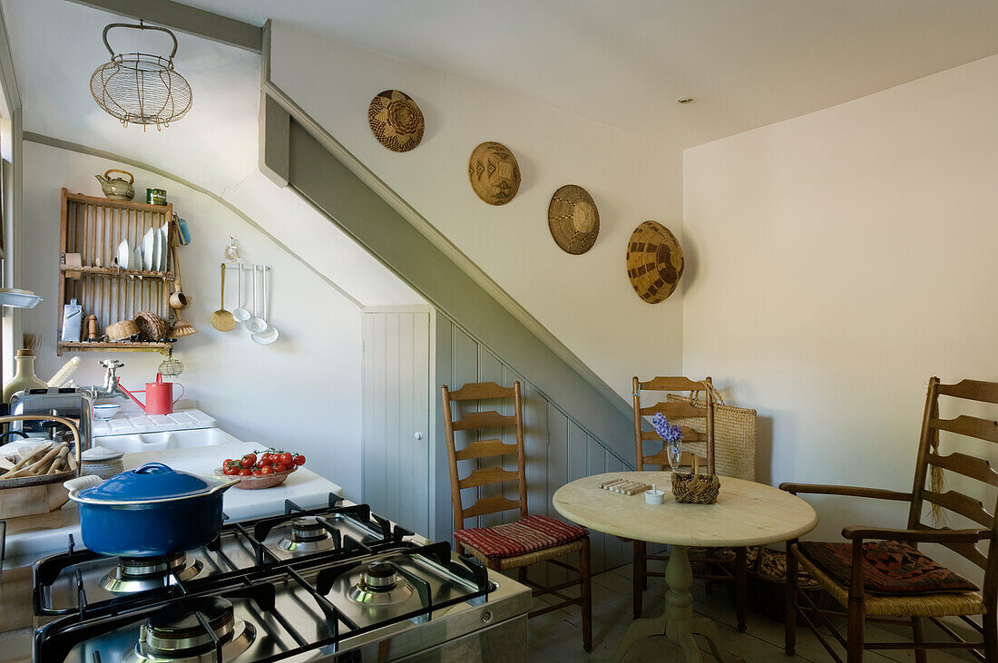 Kitchen with gas cooker, rustic wooden furniture and decorative wall baskets