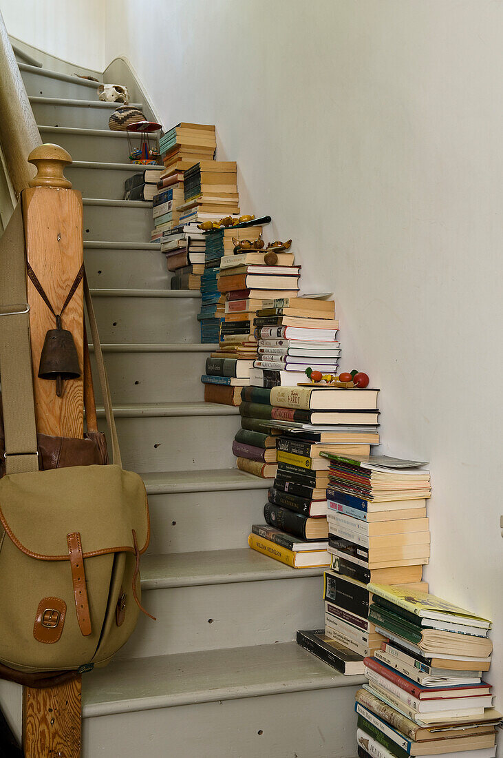 Many stacks of books on the stairs