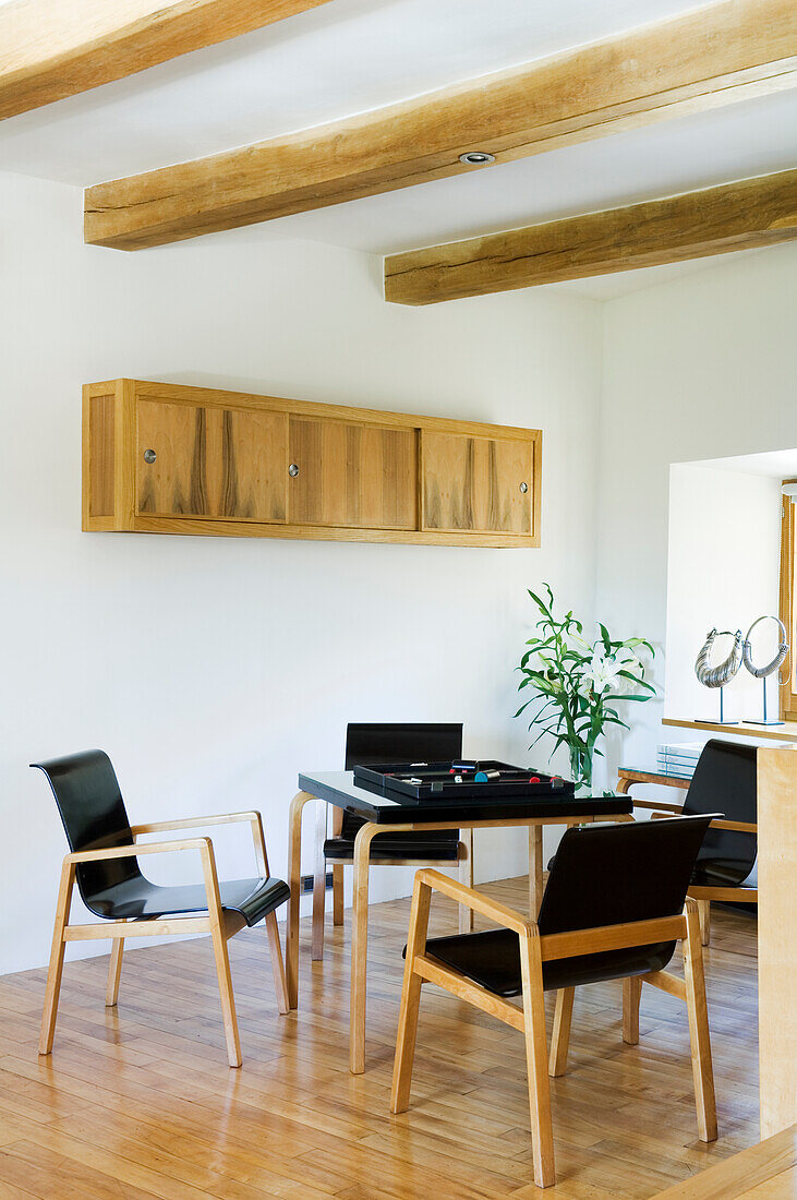 Dining room with wooden beams, dining table and black chairs