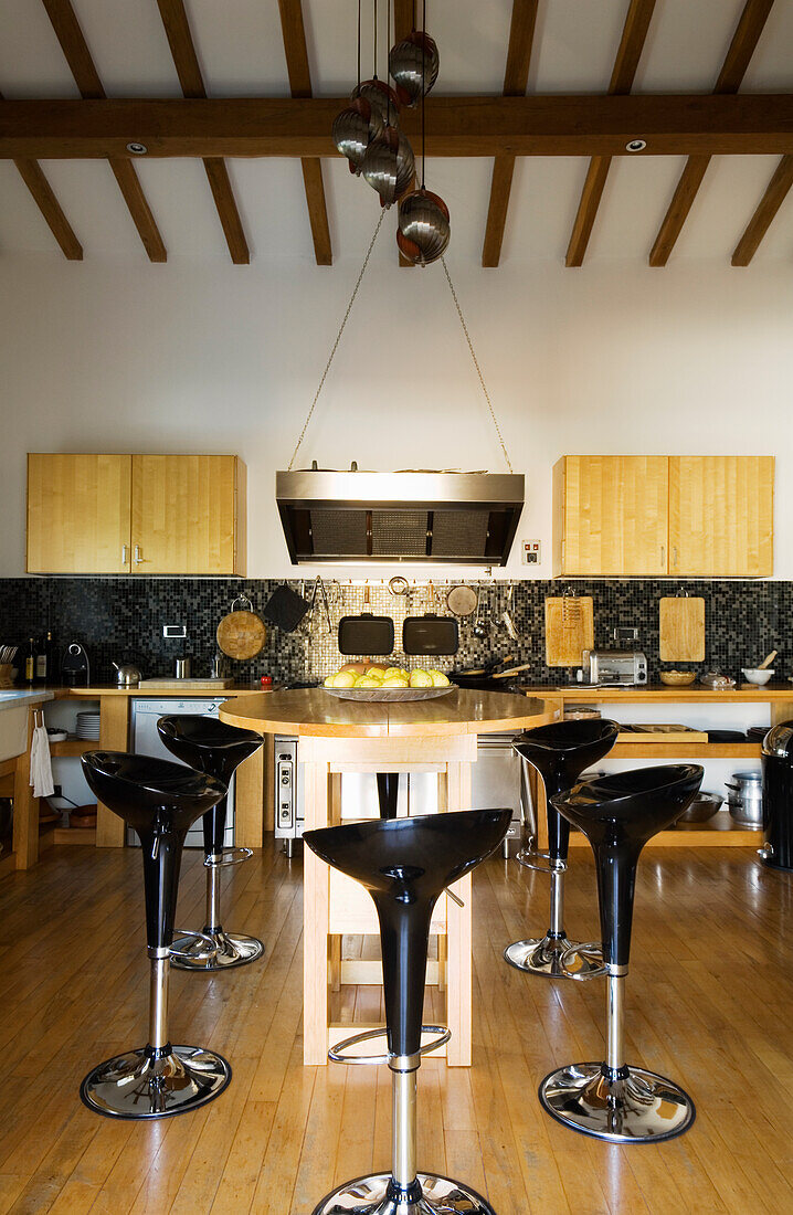 Kitchen with black bar stools and wooden furniture