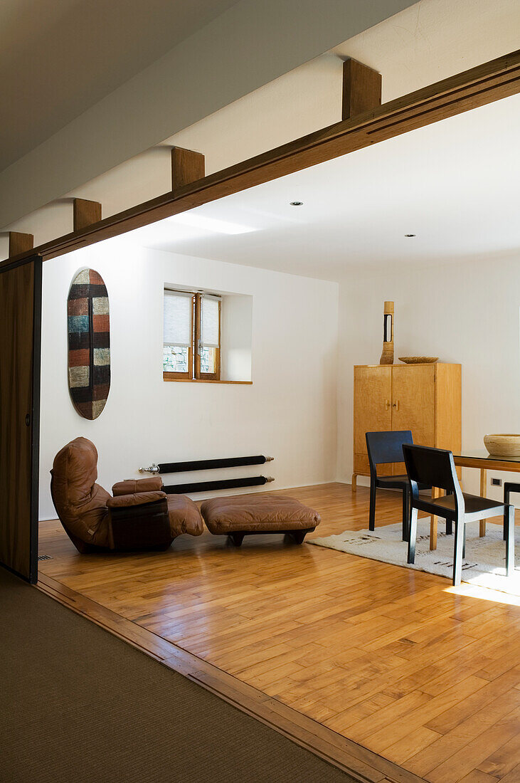 Open-plan living room with wooden floor and minimalist furnishings