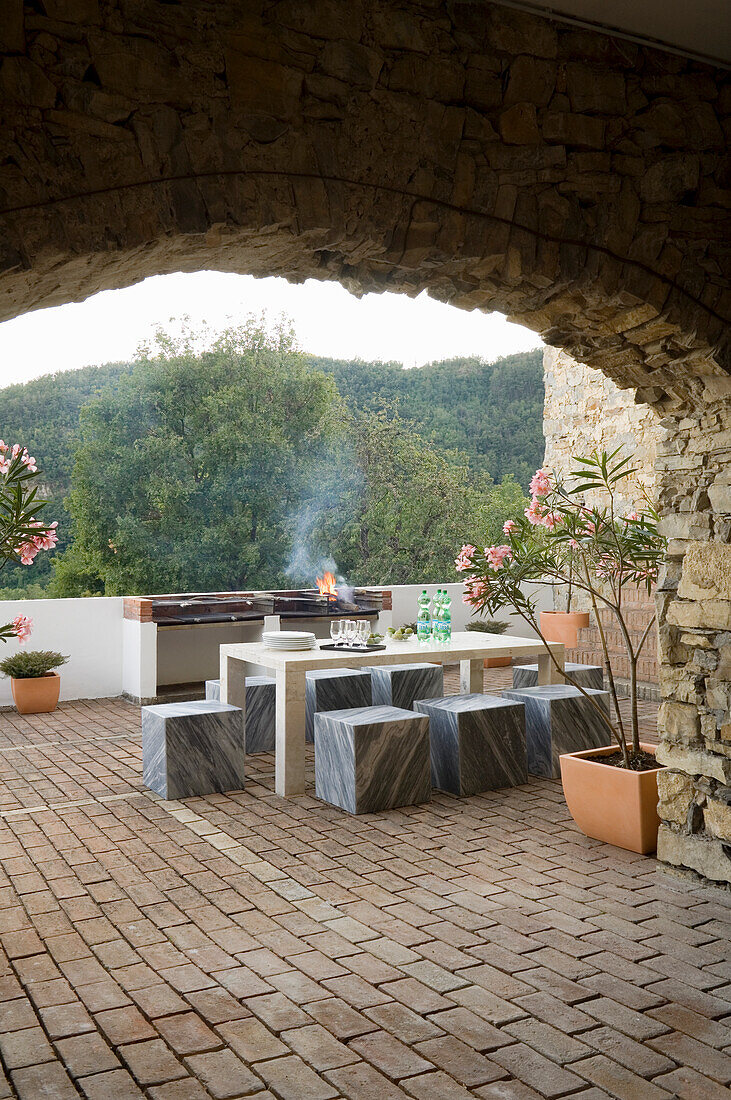 Terrace with natural stone arch, planters and marble table