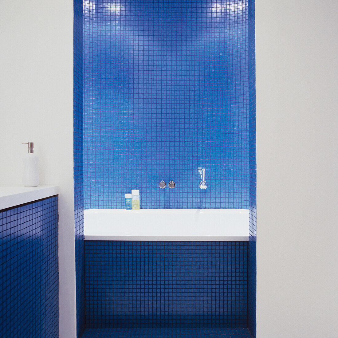 Badezimmer mit blauen Mosaikfliesen und Badewanne