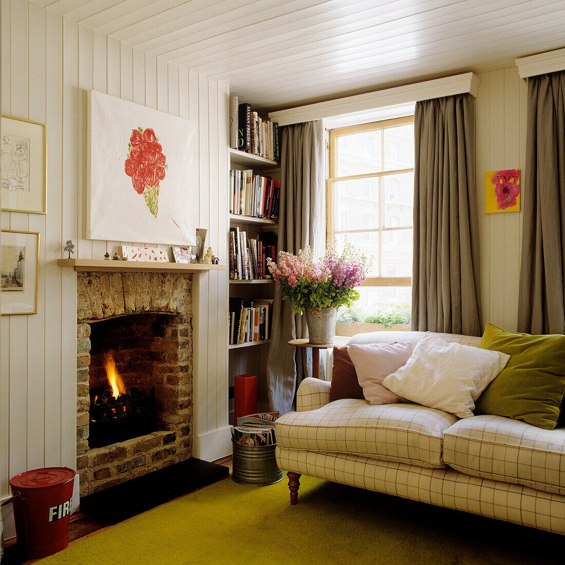 Living room with fireplace, bookshelves and cosy sofa with check pattern