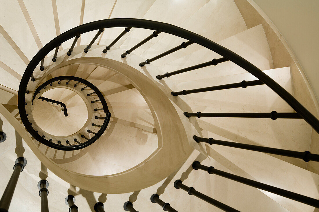 Curved stone staircase with black banisters