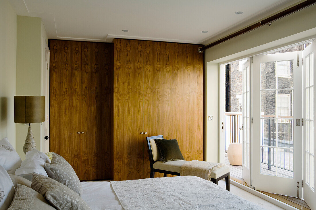 Bright bedroom with wooden wardrobe and balcony access