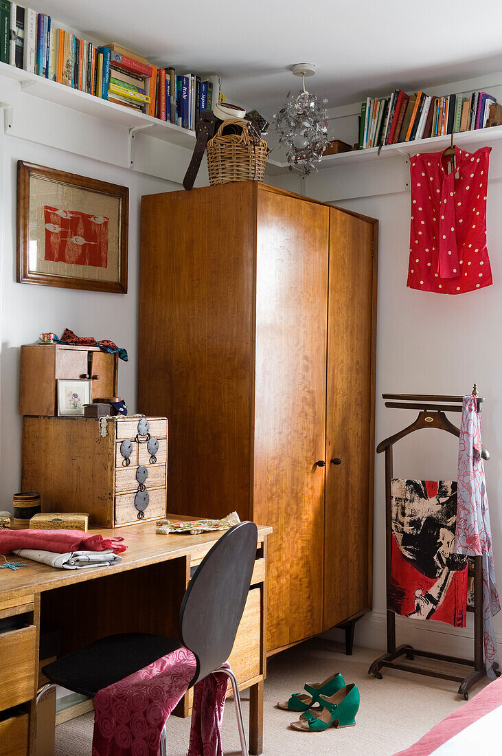 Zimmer mit Schreibtisch, Holzschrank und Bücherregalen