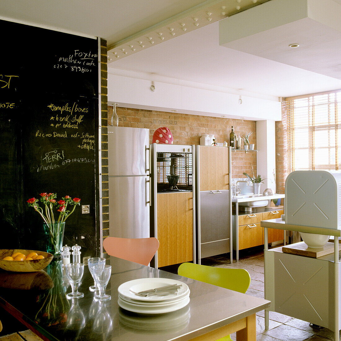 Kitchen with table, colourful chairs and blackboard wall