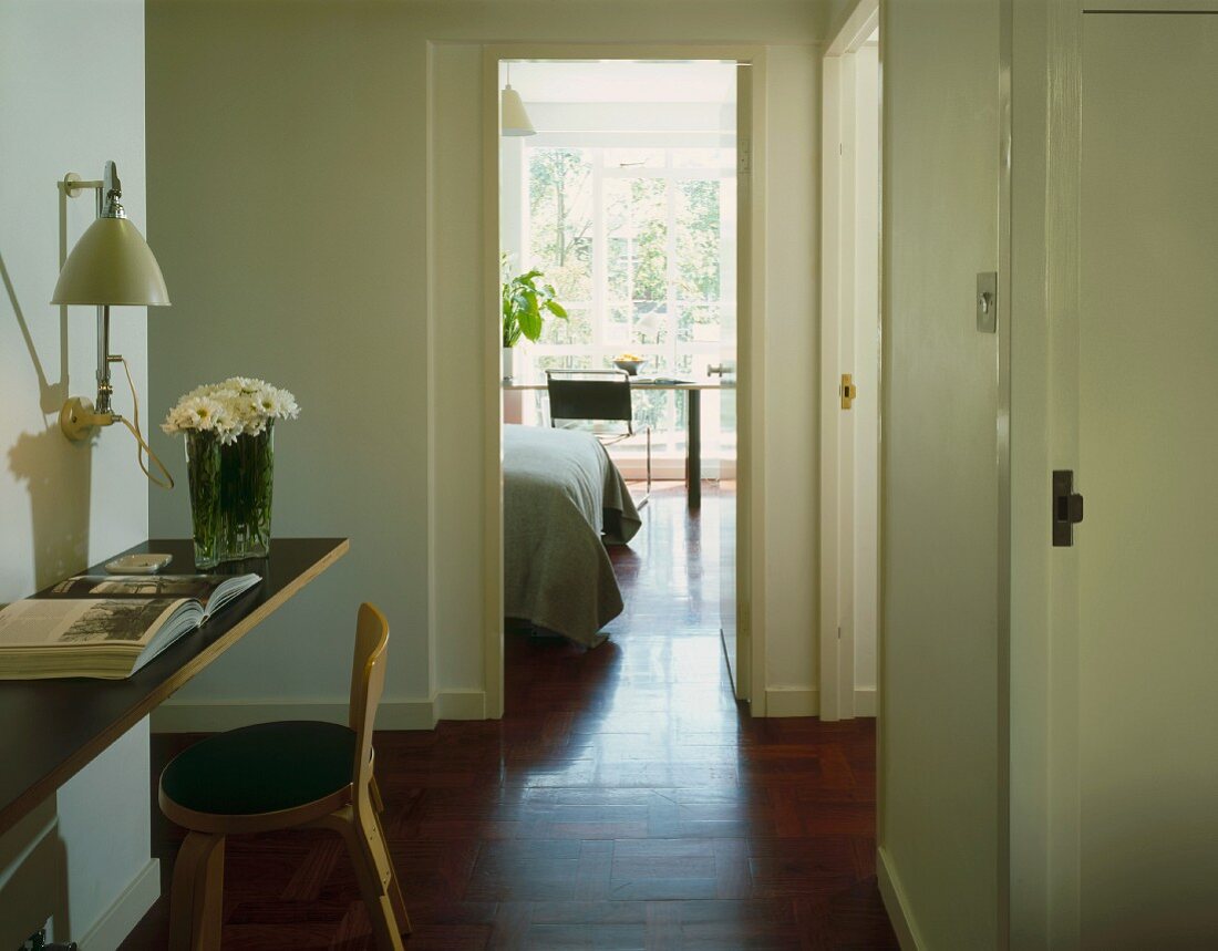 Hallway with seat & open door to bedroom