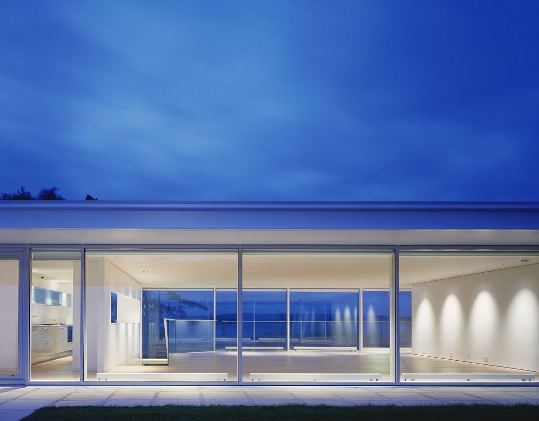 Modern house with glass walls at dusk