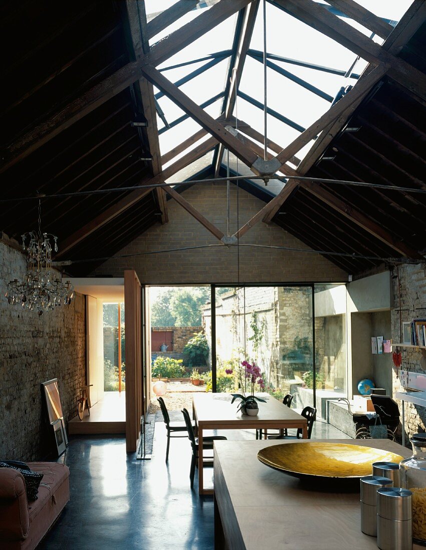 Wohnraum mit Dachkonstruktion aus Glas & Blick in Garten