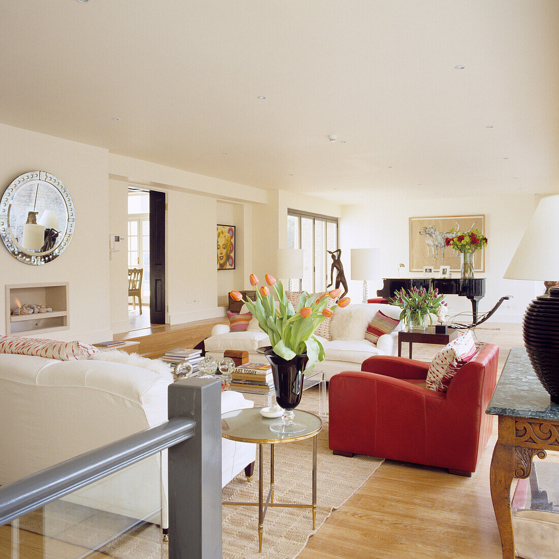 Living room with piano, red accents and wooden floor