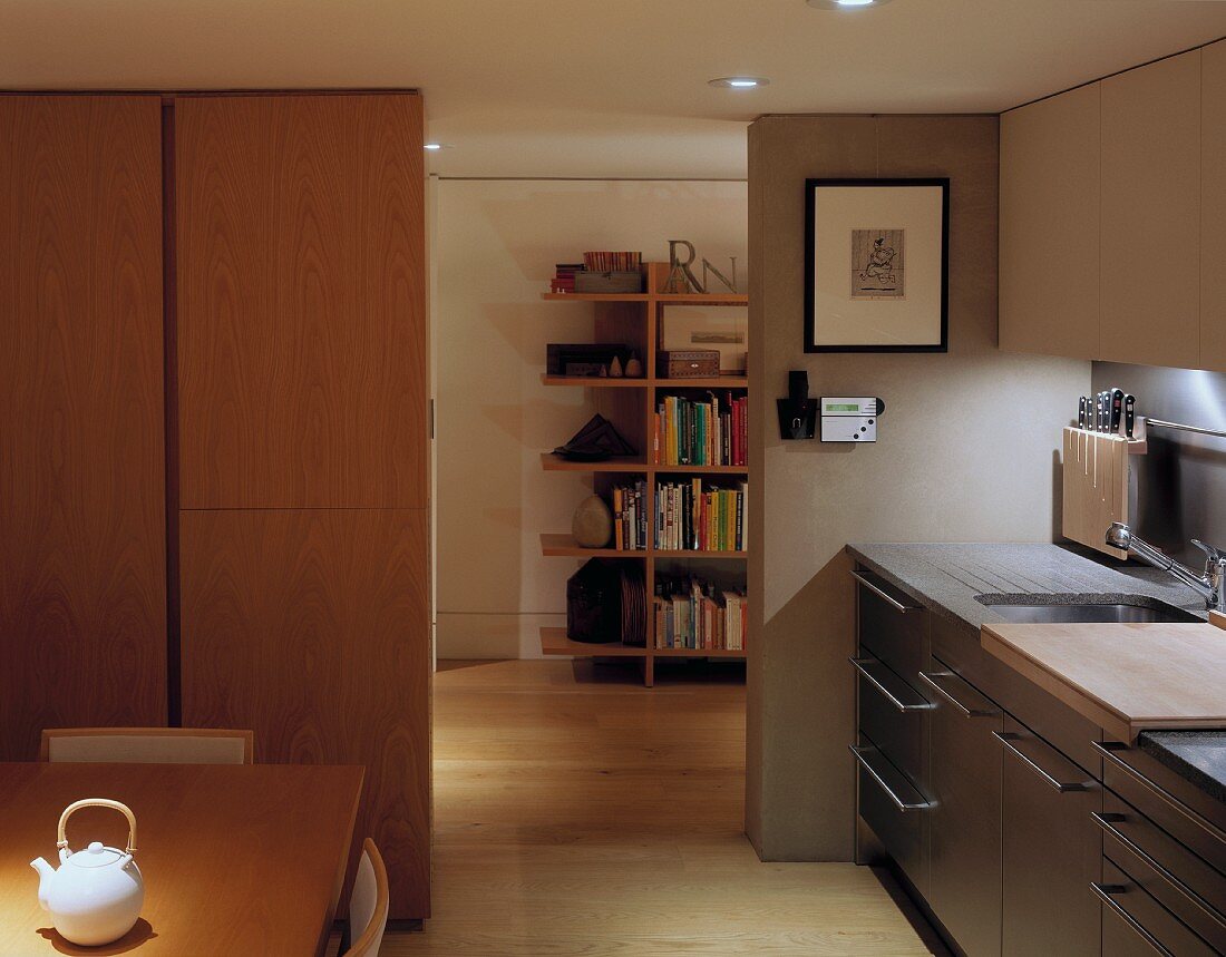 Moderne Wohnküche mit Blick auf angrenzendes Zimmer und Bücherregal