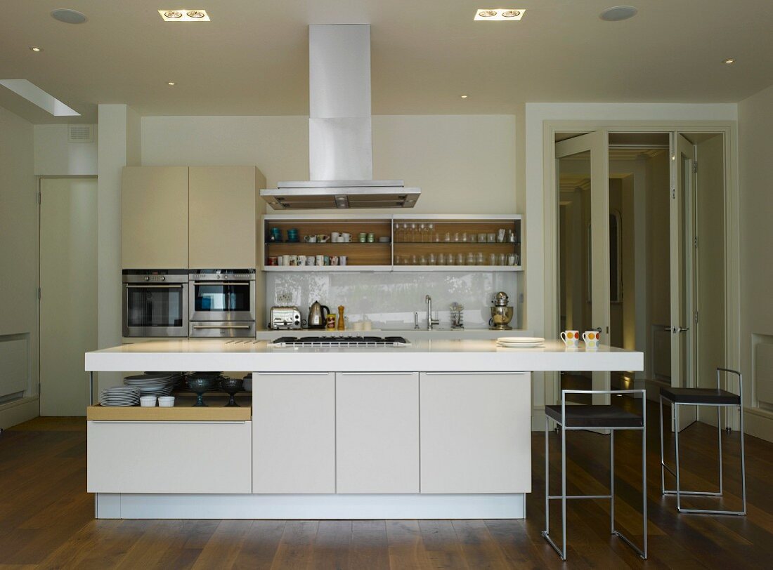 Küche in offenem Wohnraum mit Kücheninsel und zentralem Dunstabzug