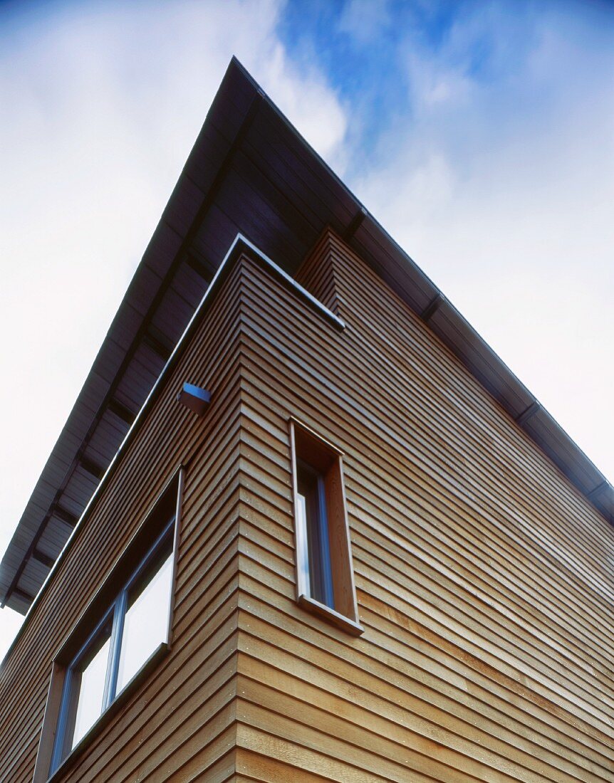 Blick nach oben auf Holzfassade eines modernen Wohnhauses