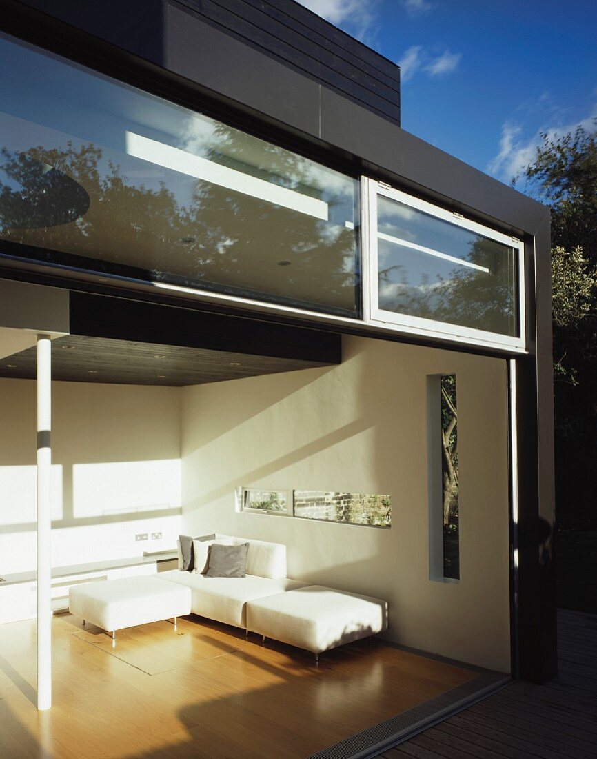 Geöffnete Terrassentüren mit Einblick in Designer Wohnraum eines zeitgenössischen Wohnhauses